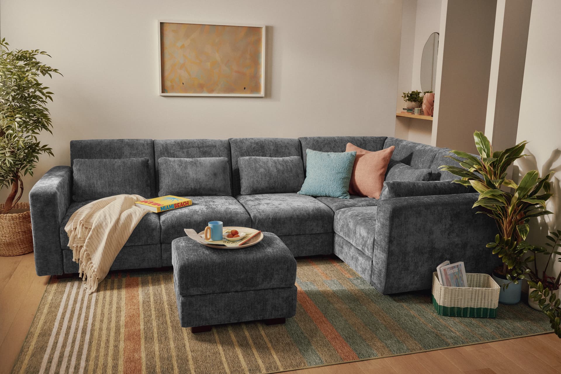 Grey Cozey Neptune sectional with an ottoman in a living room