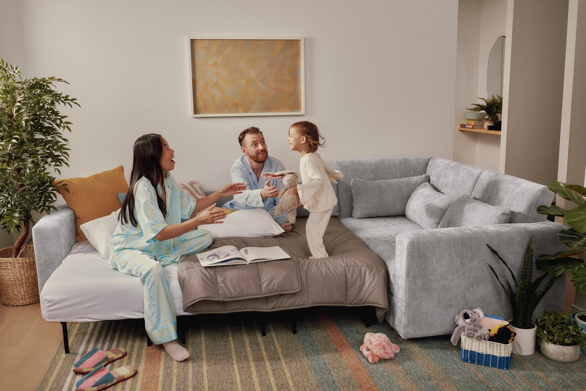 Family reading together on a cream Cozey Neptune sectional
