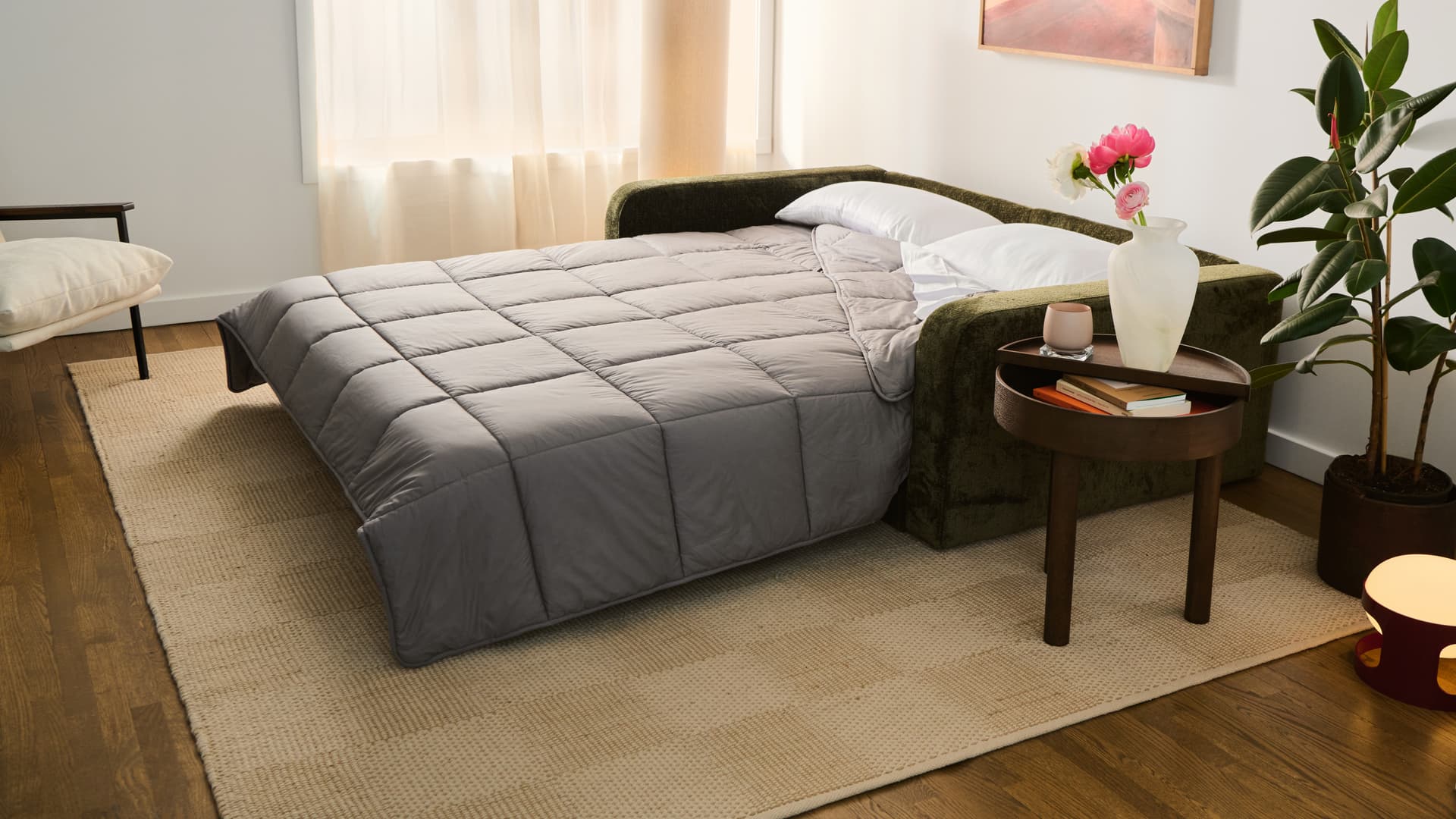 Green Cozey Orian sofa bed opened into a queen-size bed with a grey comforter