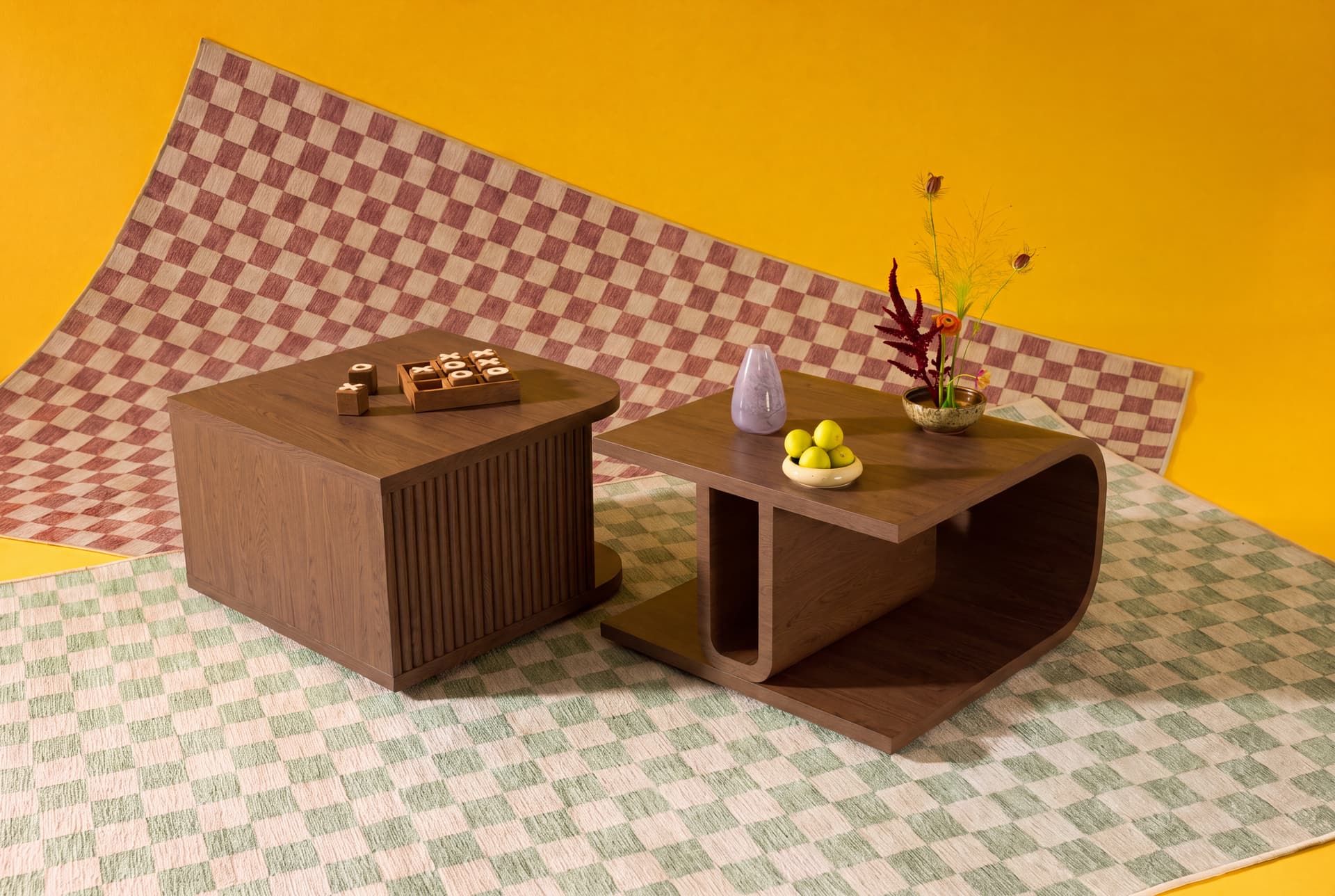 Two walnut coffee tables on a checkered washable rug against a yellow backdrop