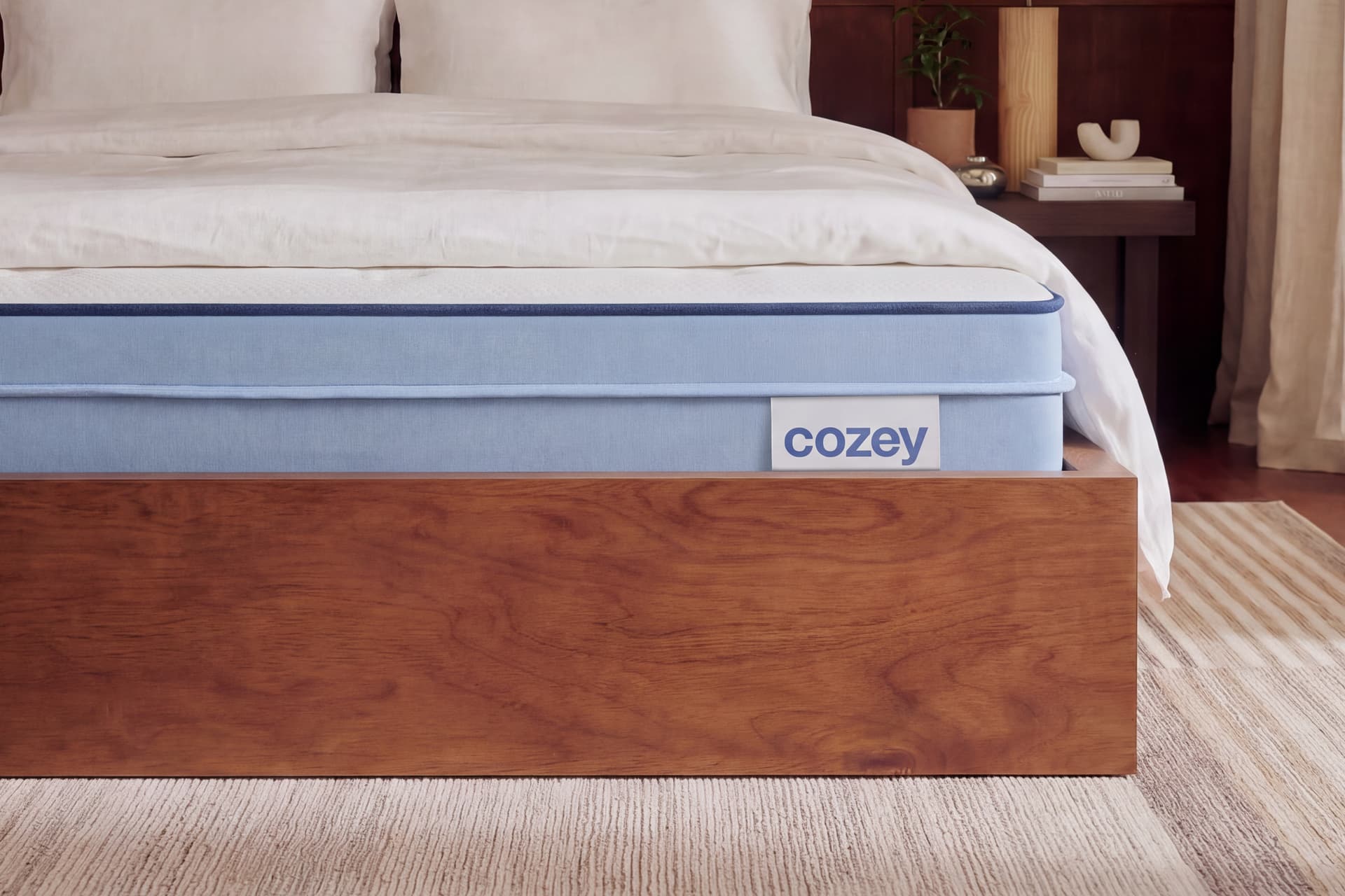 Close-up of a Cozey Hybrid mattress on a wooden bed frame