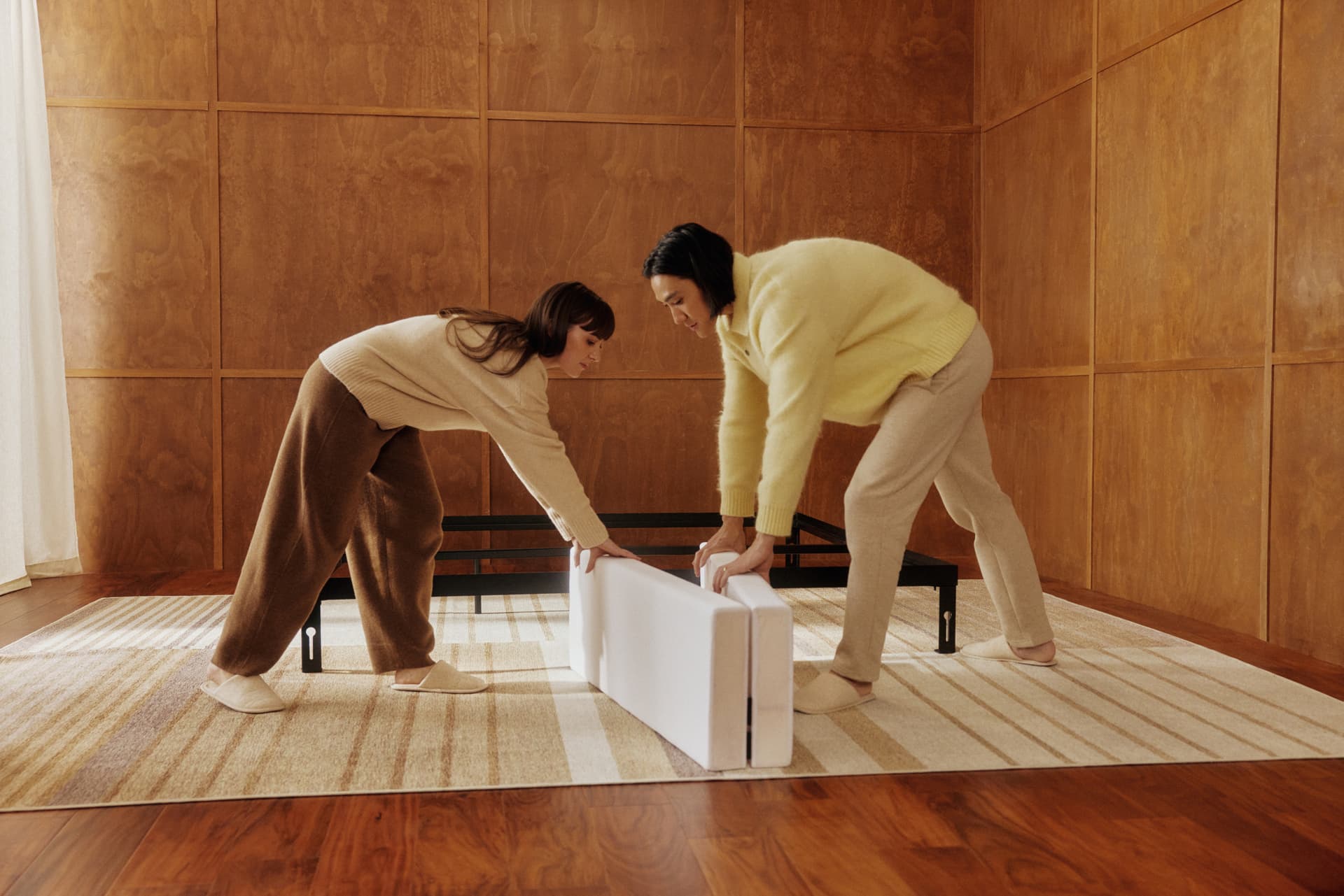 Two people assembling a bed